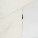 Close-up of a white garment with a brand tag on a light gray background