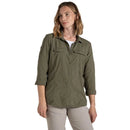 Woman wearing an olive green jacket on a beige background