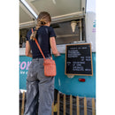 Osprey Daylite Small Crossbody Bag worn outdoors, lifestyle shot
