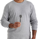 A person wearing a light gray long-sleeve shirt holds the Sea to Summit Frontier Ultralight Spork - Short Handle upright in one hand against a plain background.