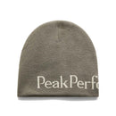 A gray double-layer knit PP Hat from Peak Performance, crafted from 100% acrylic. It features partial white PeakPerf text near the bottom edge and is photographed against a white background. This beanie blends warmth and style for everyday use.