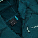 Close-up of a teal Peak Performance Mens Trail Polartec Power Grid Zip Hooded Fleece, featuring the brand label, zipper details, textured technical midlayer fabric, and a white embroidered Peak Performance logo on the chest.
