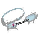 A technical crampon, shown in a semi-transparent render on a solid white background. features a light blue strap, a black central connector arm, and gray metal crampons with light blue pads.