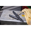 A Leatherman Surge Multitool with open pliers rests on a scratched metal surface beside a yellow work glove.