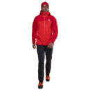 A person wearing a red Mountain Equipment Mens Lhotse GTX Pro Jacket, black pants, and orange hiking boots walks forward against a white background.
