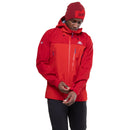 A person in a red Mountain Equipment Mens Lhotse GTX Pro Jacket and matching beanie adjusts their sleeve cuff, showing off the waterproof, breathable jacket with multiple zippered pockets; black pants are also visible.