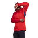 A man in a red Mountain Equipment Mens Lhotse GTX Pro Jacket raises his arm to unzip the underarm vent, showing off the blue lining. The waterproof, breathable jacket is highlighted against a plain white background.