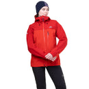 A woman wearing a red outdoor jacket, a dark navy beanie, and black pants, standing against a plain white background.