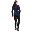 A person seen from behind wearing a dark blue Mountain Equipment Women’s Jorasses Lite Fleece Jacket, black trousers, and grey athletic shoes.