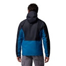 A person wearing the Columbia Mens Pouring Adventure™ III Waterproof Hiking Jacket in blue and black, paired with gray cargo pants, stands facing away—an ideal outfit for outdoor adventures.