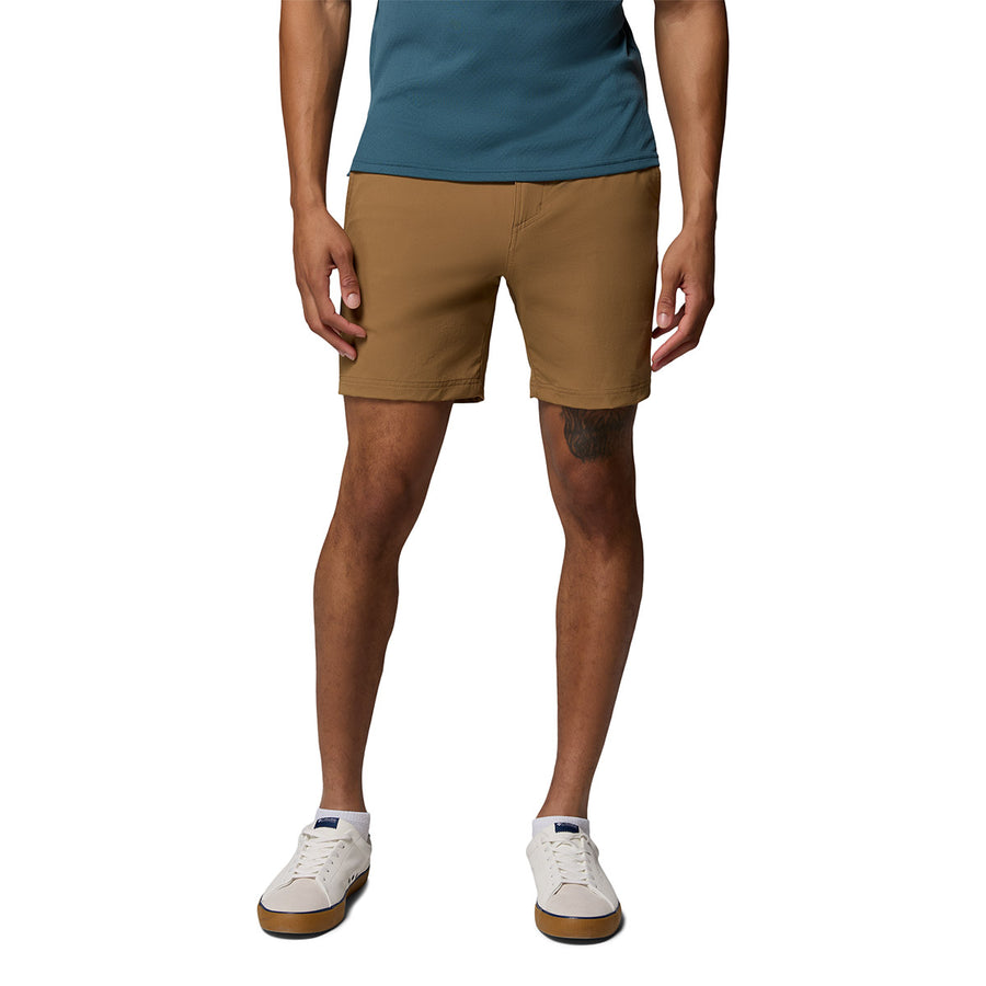 A person stands against a white background, wearing a teal shirt, Columbia Mens ROC Tech Shorts, and white sneakers. The image is cropped from the shoulders down, displaying their torso, legs, and feet.