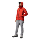 Wearing the Columbia Mens Saudan Pro™ 3L Shell Jacket in bright red, light gray pants, hiking shoes, and a black cap, a person stands slightly turned against a white background—ready for extreme conditions.