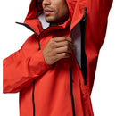 A person wearing the Columbia Mens Saudan Pro 3L Waterproof Shell Jacket unzips a large underarm vent, showcasing its ventilation feature. The focus is on the upper body and the jacket’s function for extreme conditions.