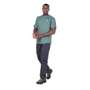 Model wearing Men’s Podus Tee green front walking