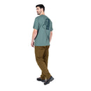 Model wearing Men’s Podus Tee green side view standing