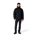 A man stands against a white background wearing the Rab Mens Microlight Shield Waterproof Down Jacket, paired with black pants and black shoes, looking straight ahead with a neutral expression. This jacket features recycled down for warmth and sustainability.