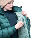 Model wearing green down jacket, adjusting zipper