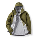 The Rab Mens Namche GTX Waterproof Jacket in olive green is displayed laid flat against a white background. Featuring a hood, front zipper partially open to reveal a light gray interior lining, and a zippered chest pocket, this shell is crafted from recycled fabric and constructed with GORE-TEX for reliable waterproof protection.