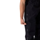 A person is shown unzipping a vertical pocket on the side of their Rab Mens Namche Hike GORE-TEX Pants, with only their arm and the side of their leg visible.