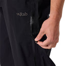 A person’s hand zips the side pocket of Rab Men’s Namche Hike GORE-TEX Pants in black, highlighting the practicality and sleek design of these waterproof hiking pants.