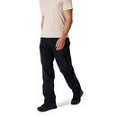 A person wearing a light beige t-shirt, black Rab Mens Namche Hike GORE-TEX Pants, and black shoes stands against a white background. The persons head is not visible in the image.