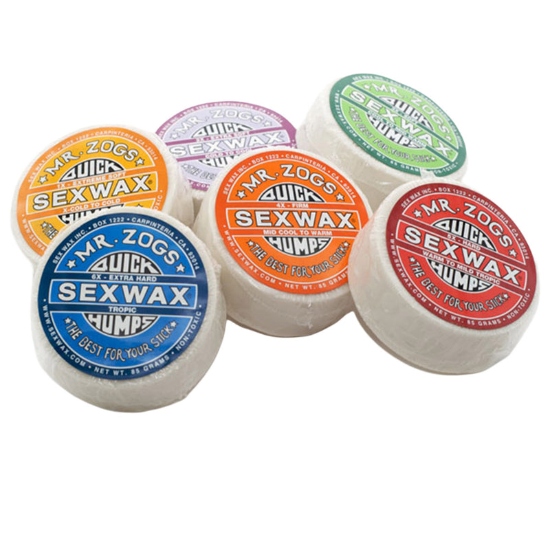 Six Original Sexwax Assorted packages by Mr. Zogs in yellow, orange, red, green, purple, and blue labels are arranged in a semicircle on a white background—ideal for surfboard traction in any water temperature.