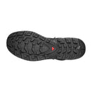 The image shows the sole of a Salomon Men’s Quest 5 GORE‑TEX Hiking Boot, featuring rugged textured tread and a red triangular accent, highlighting its waterproof design and advanced 4D chassis technology.