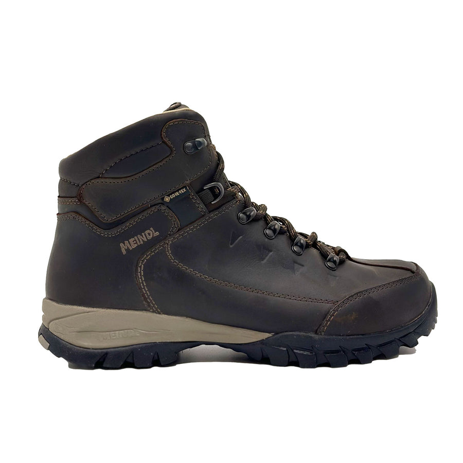 A single Meindl Mens Trento GTX Walking Boot in dark brown leather with black laces, metal eyelets, and a rugged black and gray sole is shown from the side against a white background.