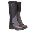 A pair of brown hiking boots fitted with Trekmates Cuillin GORE-TEX Gaiters in black and gray, designed to protect against water, dirt, and debris during mountain walks. These gaiters feature the Trekmates logo and provide coverage for the lower leg and upper boot area.