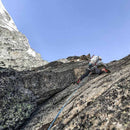 Two climbers on a rocky mountain face with clear blue sky