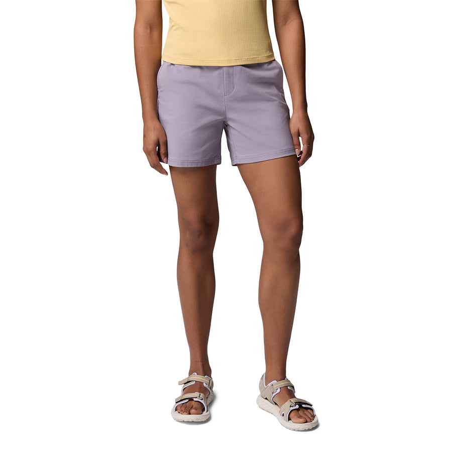 A person models Columbia Womens Cedar Crest Hiking Shorts in light purple with a yellow top and white sandals, standing against a plain white background. The photo is cropped at the shoulders, arms relaxed at their sides.