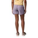 A person wearing a yellow top, Columbia Womens Cedar Crest Hiking Shorts, and sandals stands with their back to the camera against a white background.