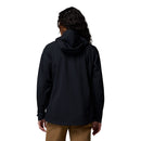 Woman with long, curly hair wears a black Columbia Womens Trailborne 2.5L Waterproof Shell Jacket and tan pants, standing with her back to the camera against a plain white background.