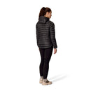A person wearing a black Rab Womens Microlight Alpine Hoody, black leggings, and tan boots stands facing away on a white background.