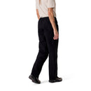 A person stands facing away, showing the back and side of their outfit, which features a beige t-shirt, black shoes, and the Rab Womens Namche Hike GORE-TEX Pants.