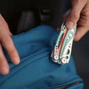 Person holding a blue bag with a multi-tool attached to it.