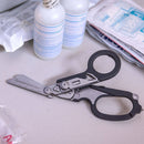 Shears on a white surface with medical supplies in the background