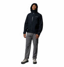 Man wearing a Columbia Trailborne jacket in black with the hood up on a white background.
