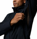 Person wearing a black waterproof jacket showing the under-arm venting with a white background