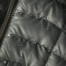 Close-up of a water-resistant fabric with droplets on a black jacket.