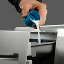 Hand pouring grangers wash & repel 2-in-1 cleaning liquid from a blue cup into a printer.