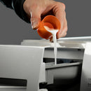 Person pouring milk from an orange cup into a printer.
