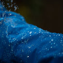 Close-up of a blue fabric with water droplets on a dark background