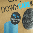 Cardboard packaging with text 'DOWN CARE' and 'NEW WOOL DRYER BALLS' on a brown background.
