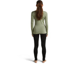 Back view of a person wearing a sage green Women’s Merino 260 Tech Long Sleeve Crew and black leggings.