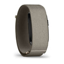 A close-up of the CIRQA Smart Band by Garmin, featuring a beige woven wristband with a black device attached, viewed from an angle that emphasizes the band and side profile of the screenless tracker—highlighting its design for 24/7 health monitoring.
