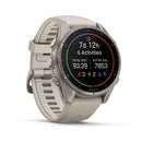 A Garmin fēnix 9 multisport GPS smartwatch in silver, featuring a light gray silicone band, presents fitness stats—such as steps, calories, activities, and time—on a vivid black circular AMOLED display with vibrant icons.