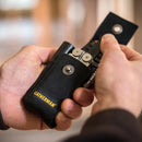 Black Leatherman nylon pouch with pockets being held open on a blurred background