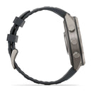 Side view of a gray Garmin fēnix 9 Pro inReach multisport GPS smartwatch with a round case, two buttons, and a crown, featuring a textured black strap and buckle.