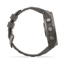 Side view of the Garmin fēnix 9, a rugged wristwatch in dark gray featuring a textured band and three round buttons on the case.